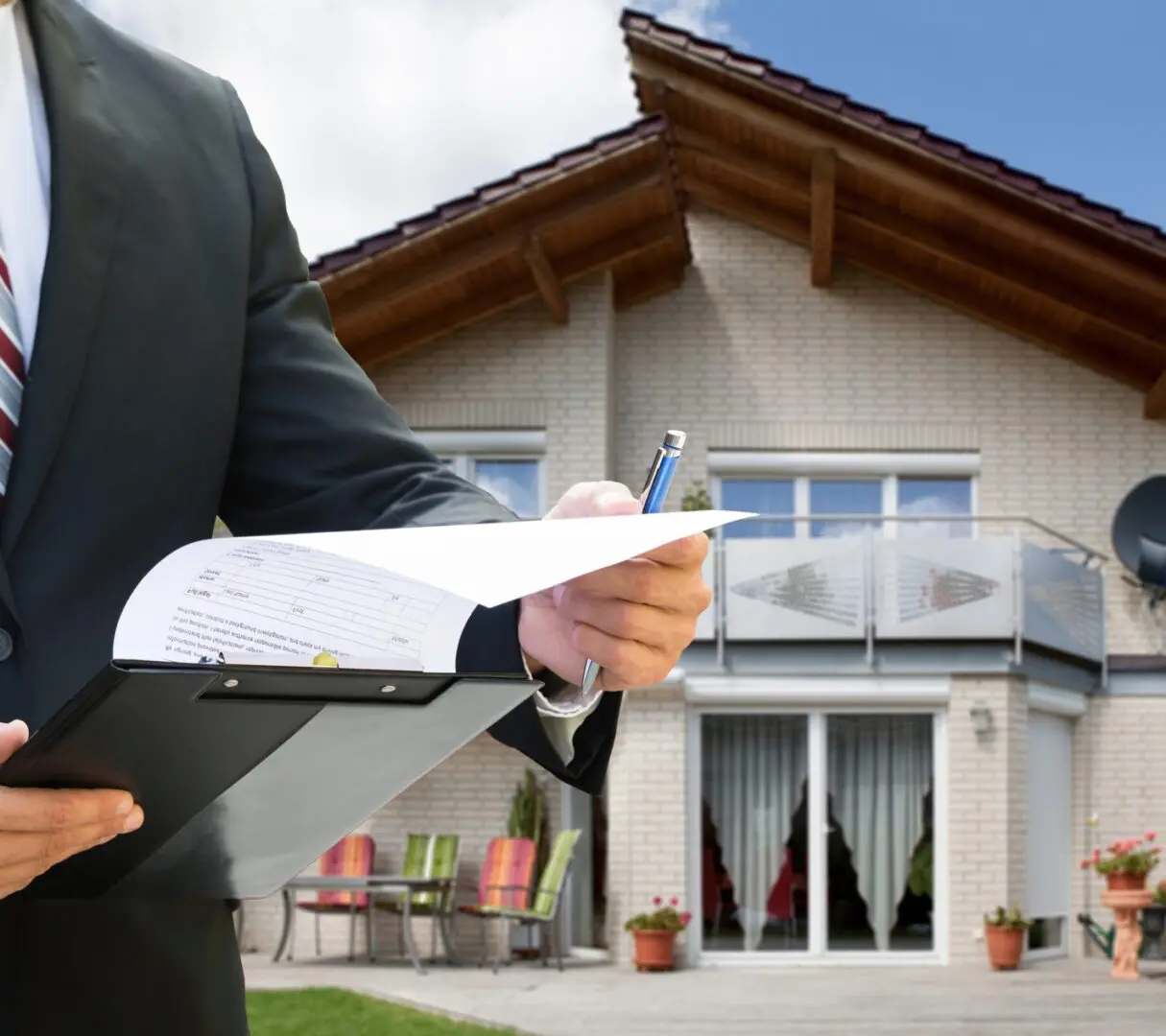 Man reviewing documents outside modern house.